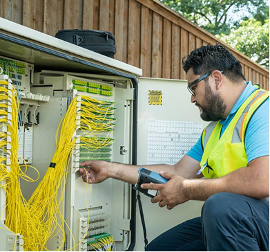 Technician inspecting fiber optic box